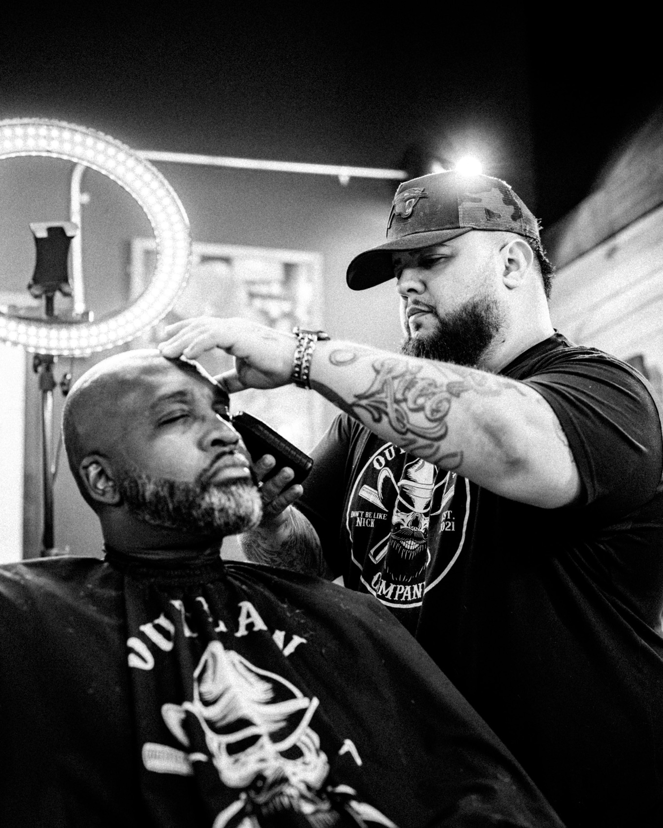 A barber at work with a client inside Outlaw Barber Company Goose Creek