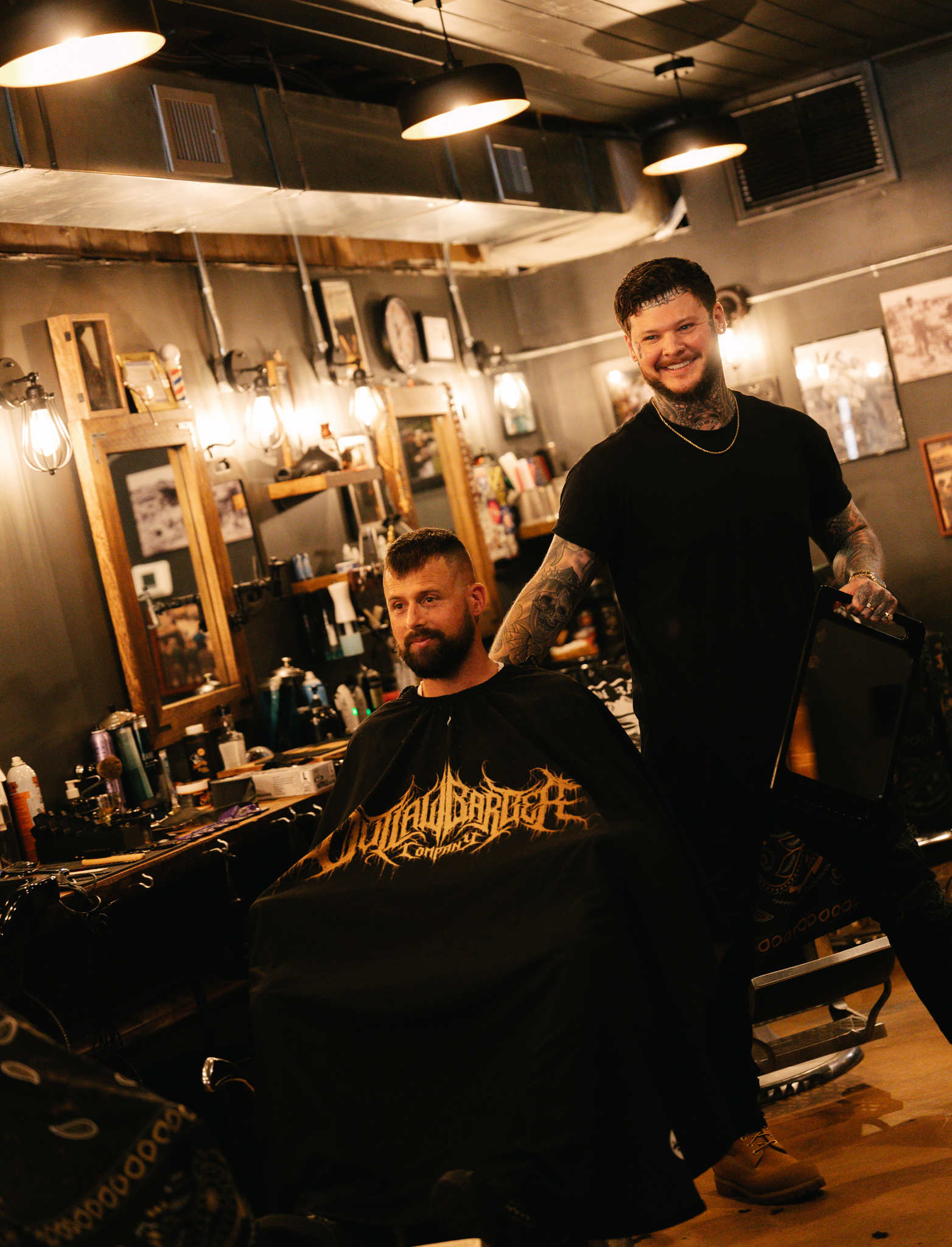 A barber consulting with a client at Outlaw Barber Company