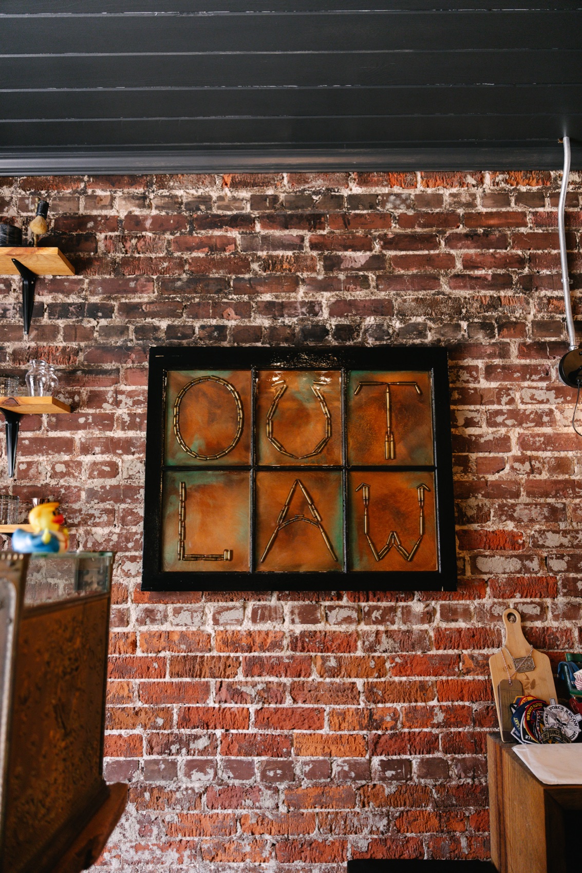 Outlaw sign on the brick wall inside Outlaw Barber Company Summerville